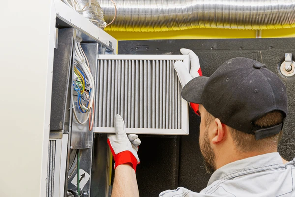 HVAC technician replacing furnace filter in Westland MI